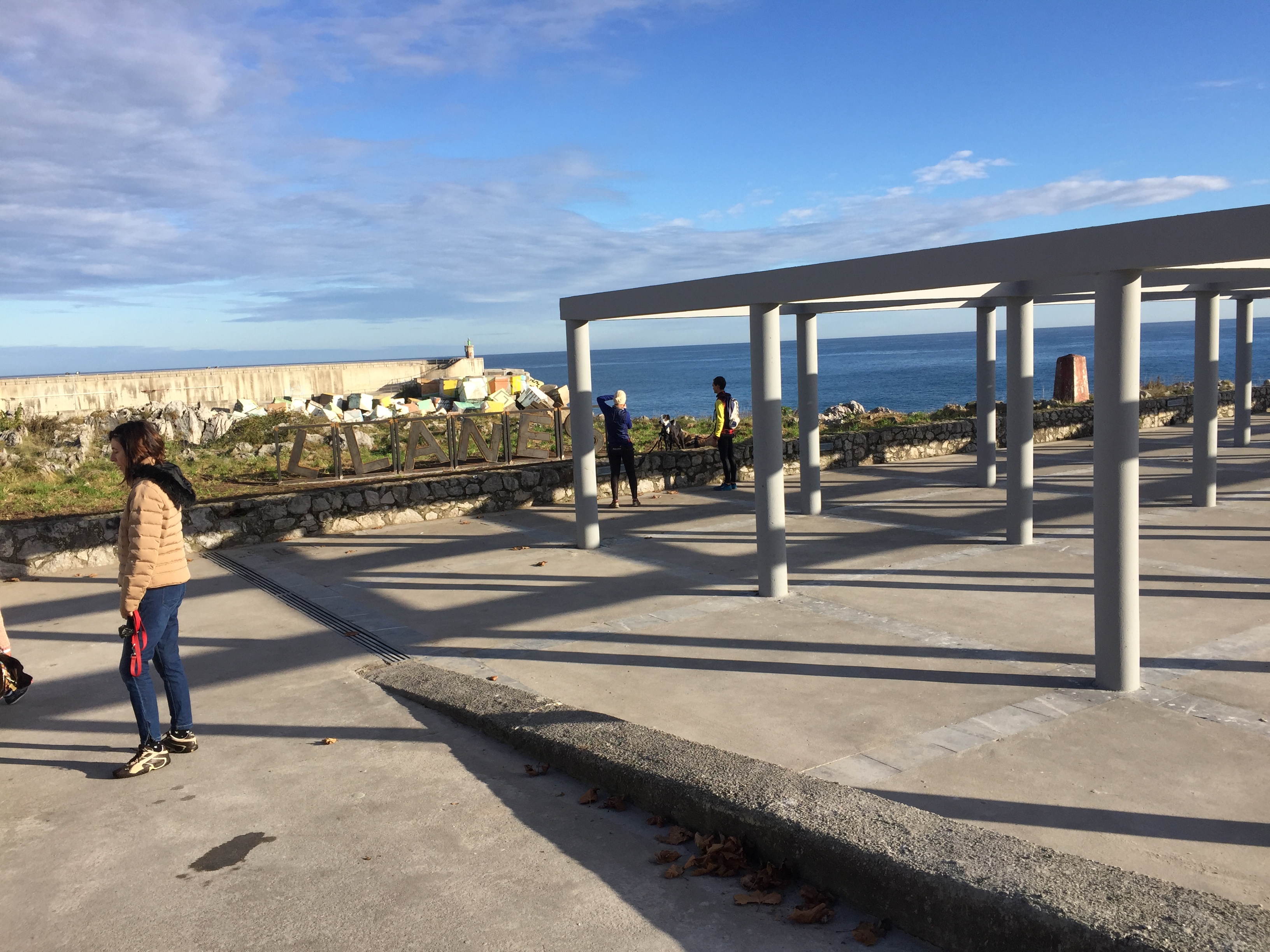 Tendedero de redes y rótulo de Llanes con los Cubos de la Memoria al fondo.